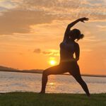 Image of a woman doing yoga at sunset