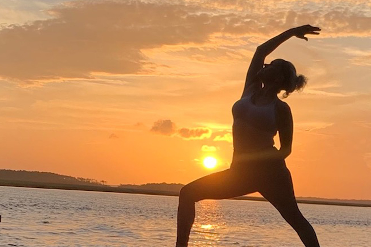 Image of a woman doing yoga at sunset